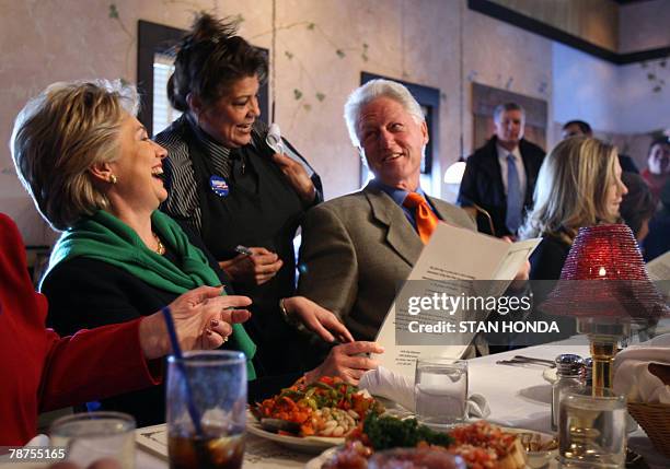 Waitress Dawny Valdez helps Democratic presidential hopeful and New York Senator Hillary Clinton , husband former US President Bill Clinton and...