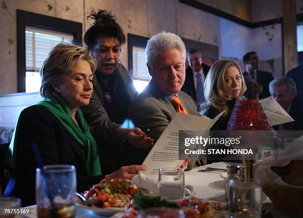 Waitress Dawny Valdez helps Democratic presidential hopeful and New York Senator Hillary Clinton , husband former US President Bill Clinton and...