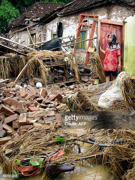 Kuntiana looks at her destoryed house following a flood in her neighbourhood in Ponorogo of East Java province, 27 December 2007. Hundreds of...