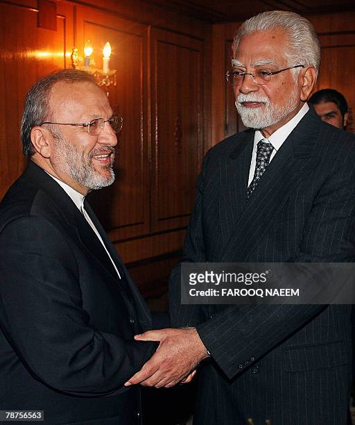 Visiting Iranian Foreign Minister Manouchehr Mottaki shakes hands with his Pakistani counterpart Inam-ul-Haq ahead of a meeting at the foreign...
