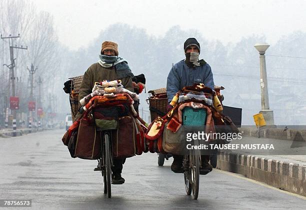 Kashmiri vendors cycle with their wares around Dal Lake in Srinagar, 04 January 2007. The Kashmir valley is reeling under continuous cold conditions...