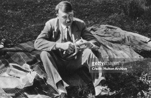 German Nazi leader Adolf Hitler enjoys a quiet picnic between meetings, circa 1933. Picture 196 of a series of collectable images published in...