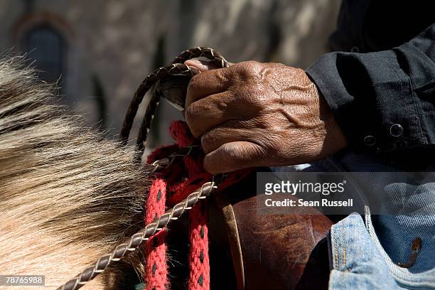 detail of a man on horseback holding the reins - sattel und zaumzeug stock-fotos und bilder