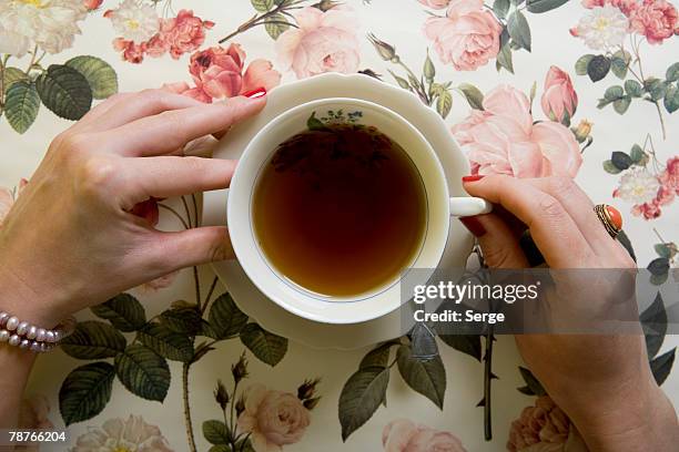 a woman drinking a cup of tea - tea cup photos et images de collection