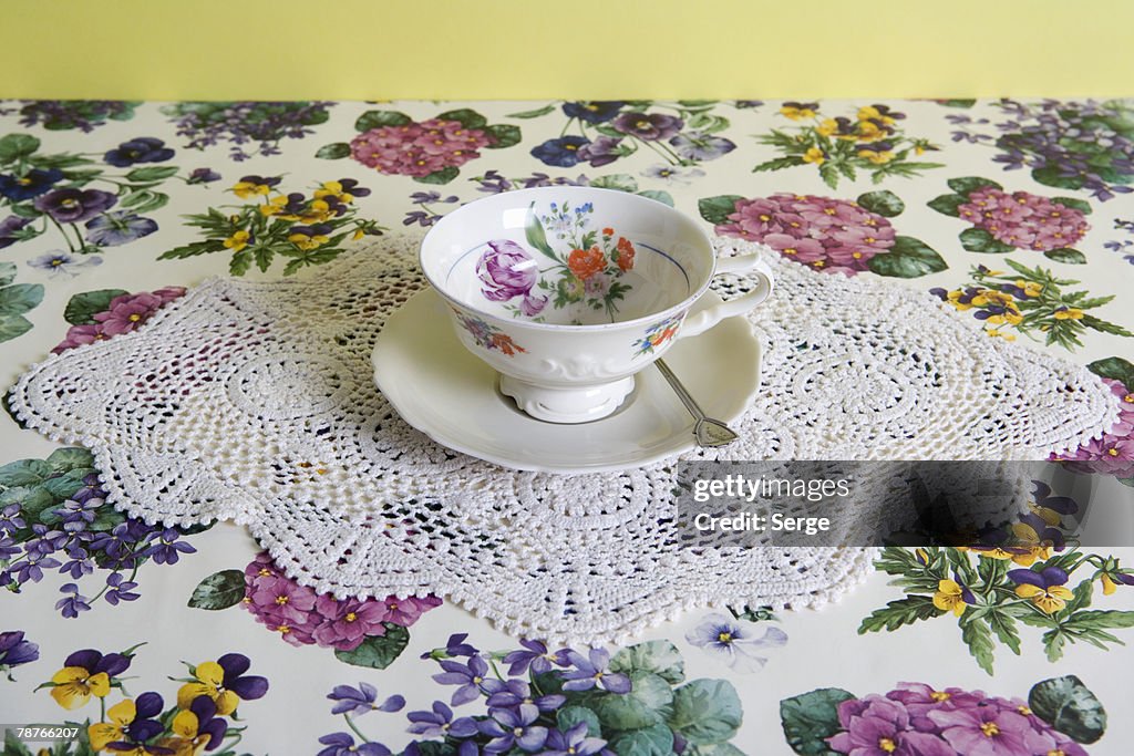 A cup of tea on a floral tablecloth