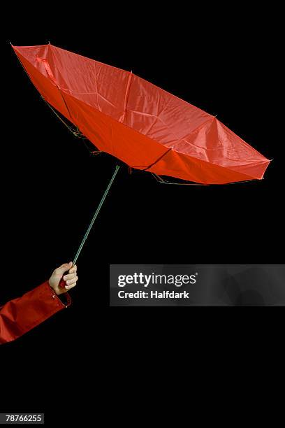 a woman holding an inside out umbrella - hands in the air stock-fotos und bilder