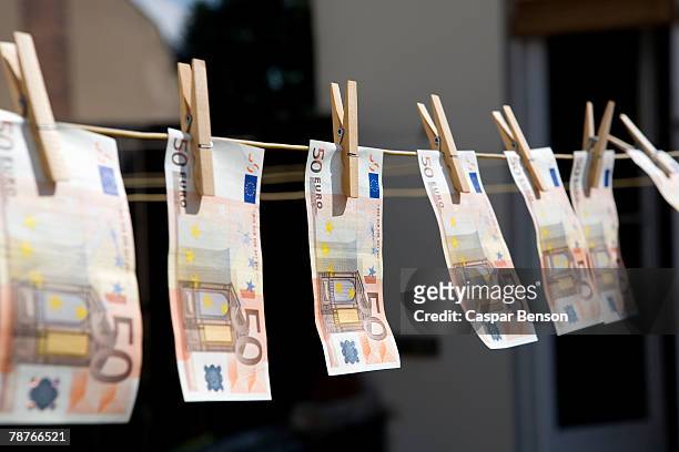 money on a washing line - money laundery stockfoto's en -beelden