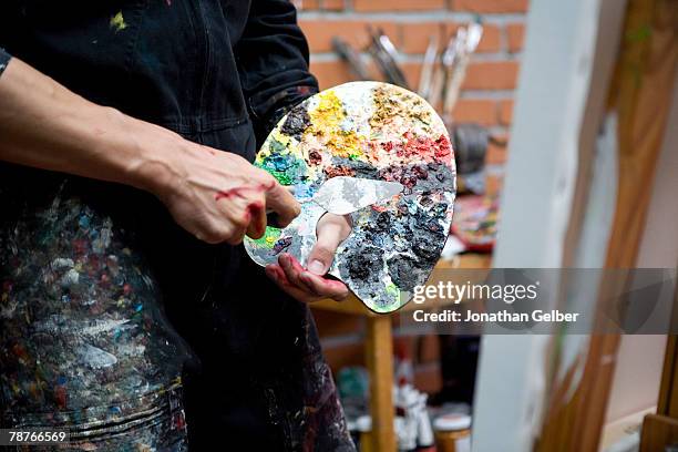 detail of an artist holding a palette and a painting knife - palet stockfoto's en -beelden
