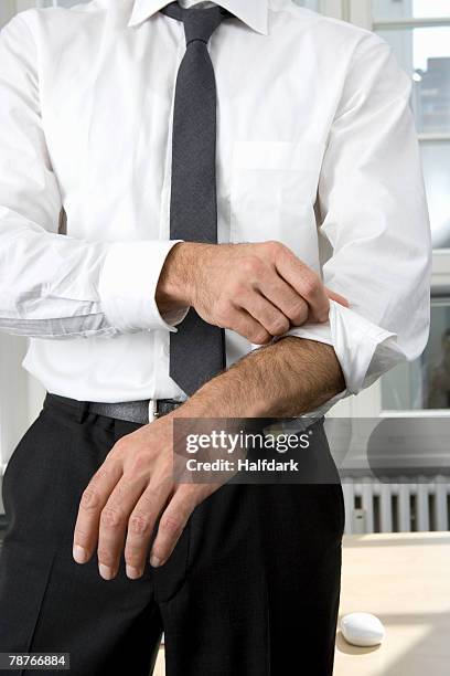 a businessman rolling up his sleeves - roll shirt stock pictures, royalty-free photos & images