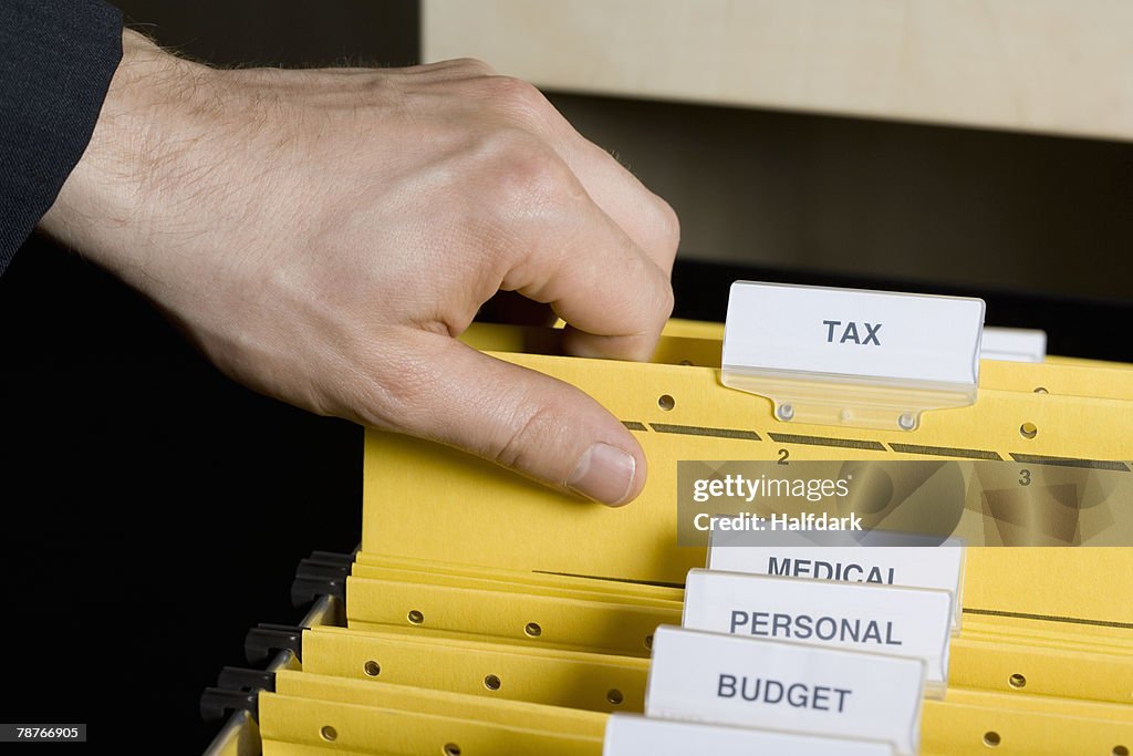 A hand picking up a file