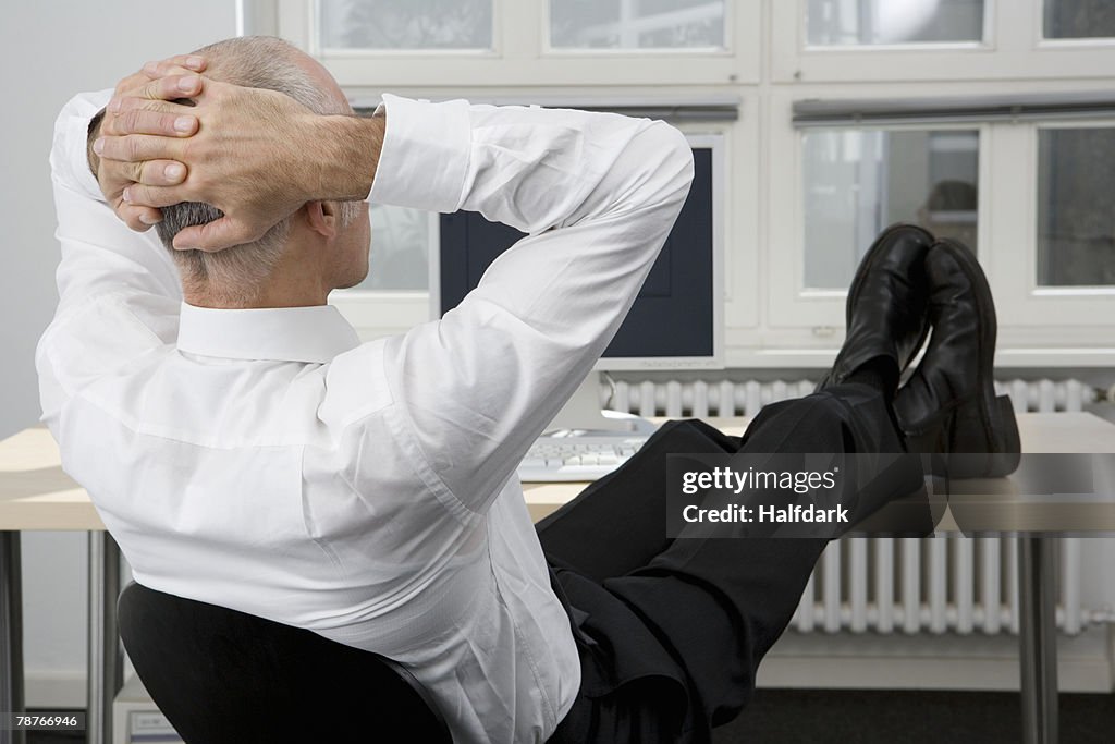 A man sitting with his feet up on a desk