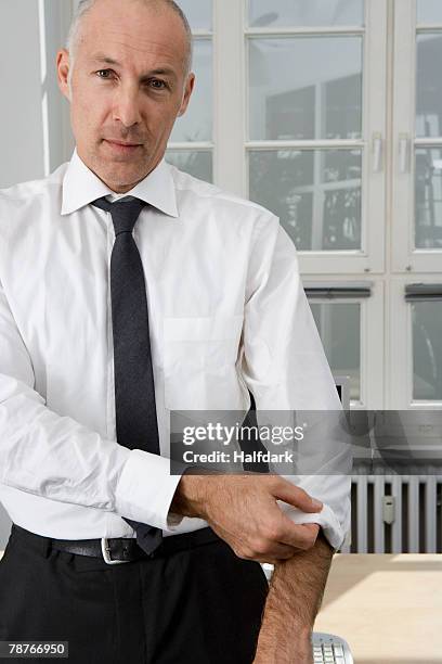 a businessman rolling up his sleeve - roll shirt stock pictures, royalty-free photos & images