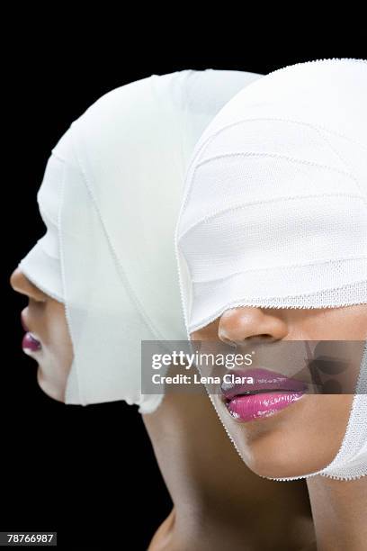 a woman with bandages wrapped around her face - painful lips stock pictures, royalty-free photos & images