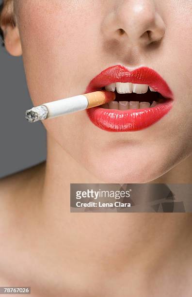 a woman wearing red lipstick and smoking a cigarette - beautiful women smoking cigarettes stock pictures, royalty-free photos & images