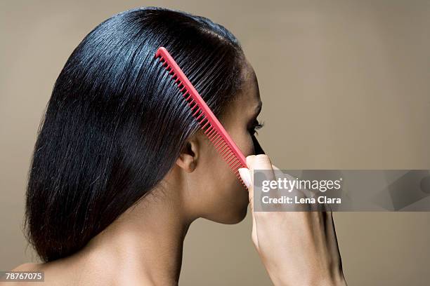 a woman combing her hair - brushed back hair stock pictures, royalty-free photos & images