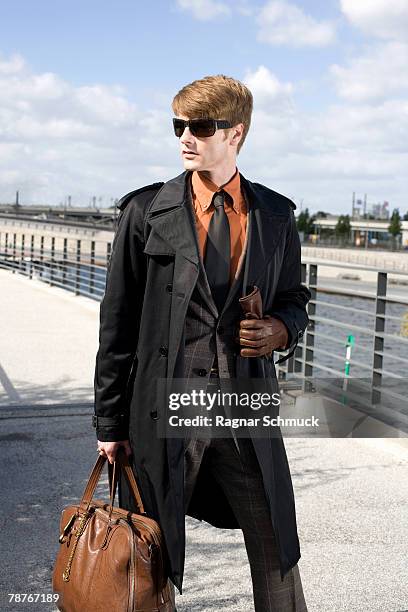 a businessman walking across a bridge - leather glove stockfoto's en -beelden