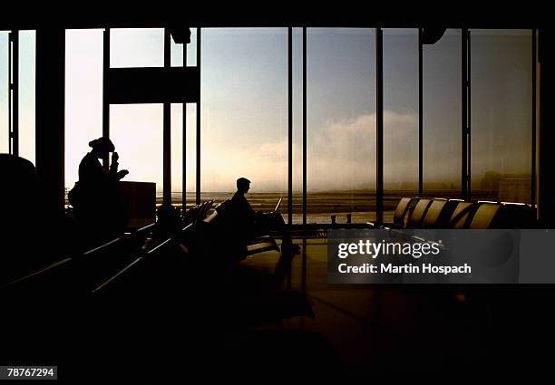 people waiting in an airport departure lounge - personas en el fondo fotografías e imágenes de stock