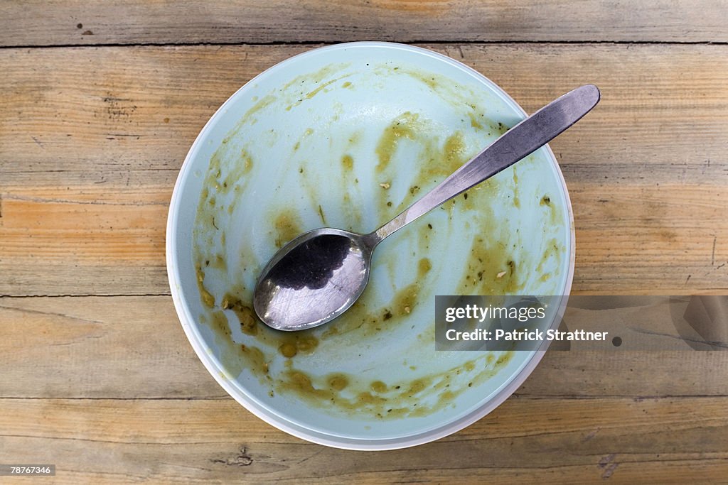 An empty soup bowl with a spoon