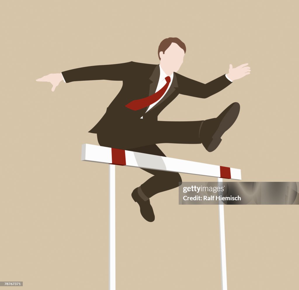 A businessman jumping over a hurdle