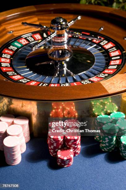 roulette wheel with stacks of gambling chips - roulette stock pictures, royalty-free photos & images