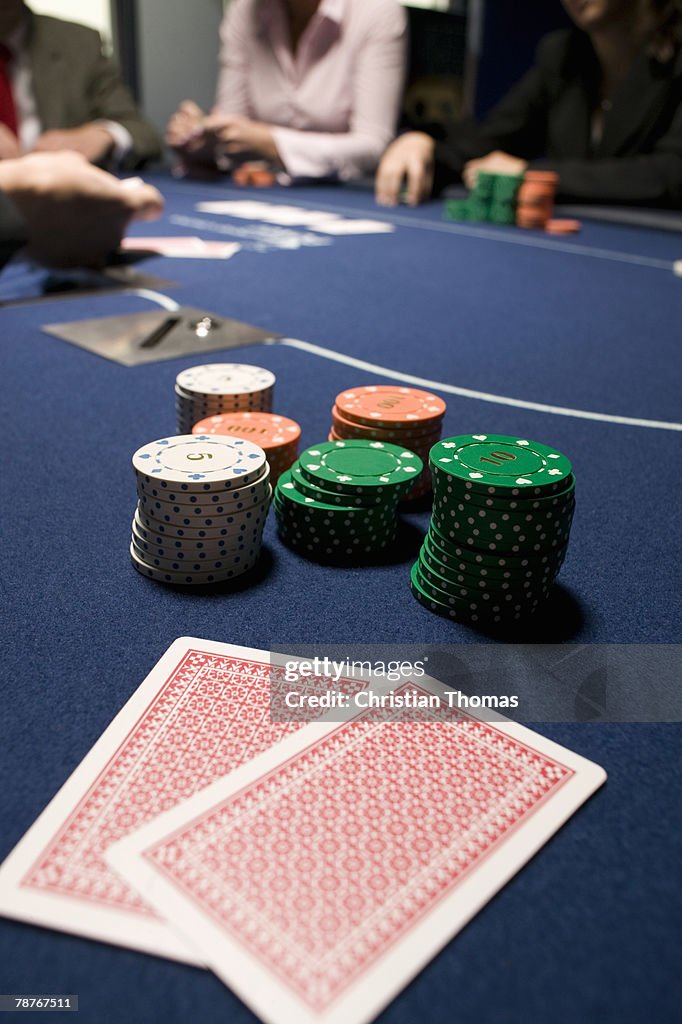 Playing cards and stacks of gambling chips on casino table