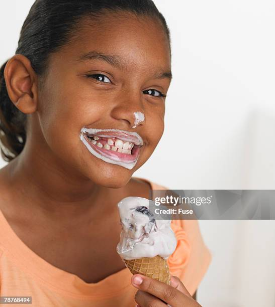 girl eating ice cream cone - girl eating messy ice cream cone stock-fotos und bilder