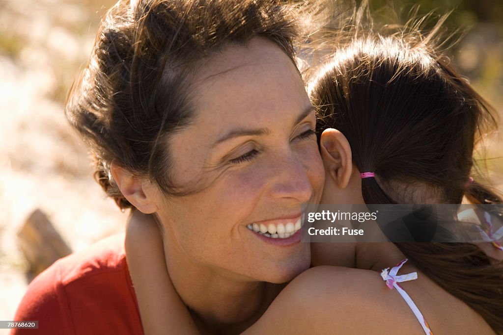 Daughter and Mother Hugging Outdoors