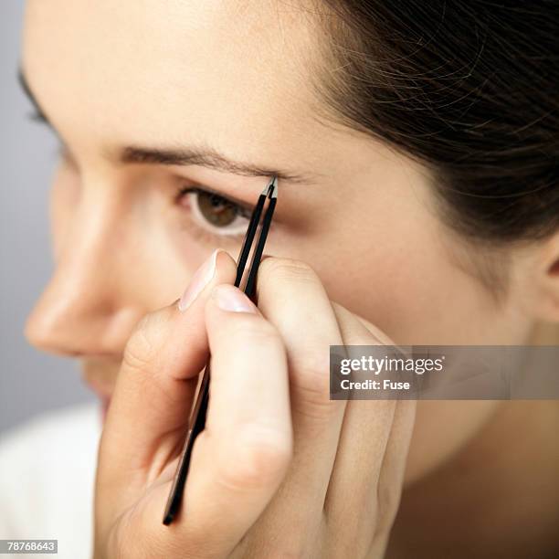 woman plucking eyebrows - eyebrow pencil fotografías e imágenes de stock