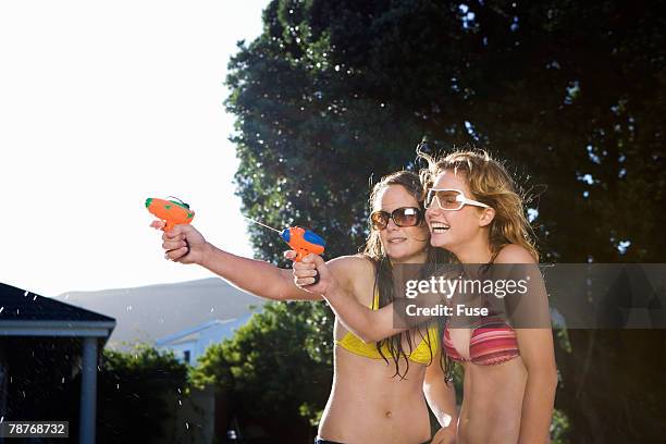 teenage girls with squirt guns - young teen bathing suit stock pictures, royalty-free photos & images