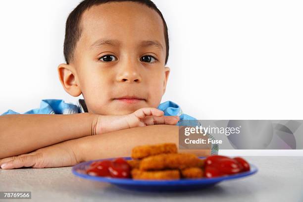 boy with plate of chicken nuggets - eating nuggets ストックフォトと画像