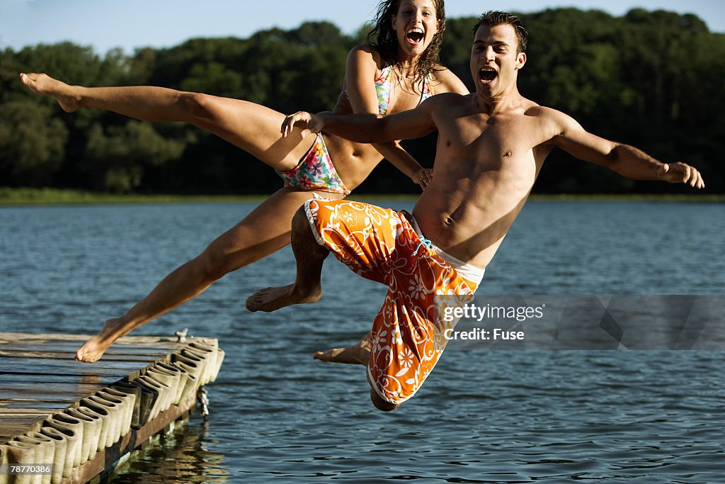 Young Couple Jumping into Lake