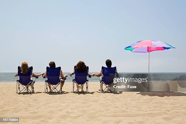 couples relaxing at the beach - beach seat stock pictures, royalty-free photos & images