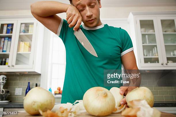 man crying while chopping onions - ui stockfoto's en -beelden