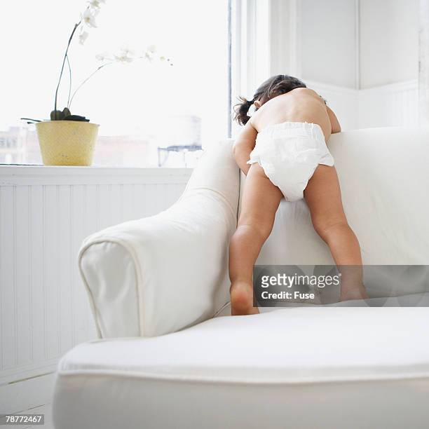 toddler peeking over sofa - baby bottom stock pictures, royalty-free photos & images