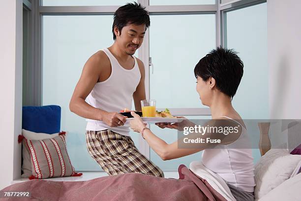 man bringing woman breakfast in bed - wellness kindness love stock pictures, royalty-free photos & images