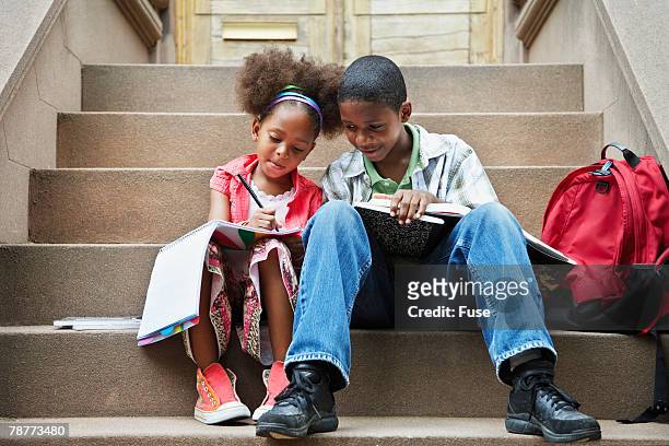 siblings doing homework on stairs - step brother stock pictures, royalty-free photos & images