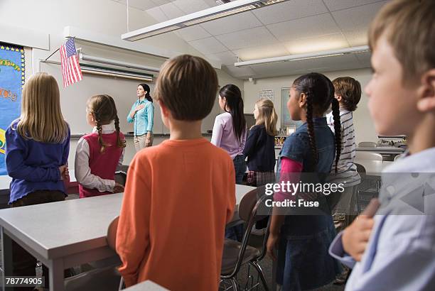 students and teacher pledging allegiance to the flag - amerikanischer treueschwur stock-fotos und bilder