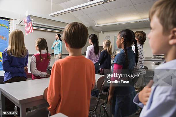 students and teacher pledging allegiance to the flag - pledge of allegiance fotografías e imágenes de stock