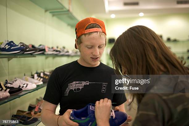 teenage couple shopping in shoe store - teenager boy shopping stock-fotos und bilder