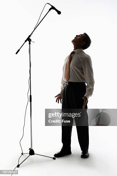 businessman yelling at tall microphone - microphone stand - fotografias e filmes do acervo