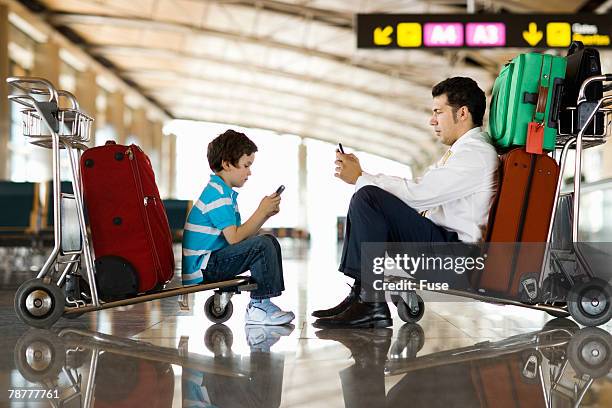 businessman and boy at the airport - airport sitting family stock pictures, royalty-free photos & images