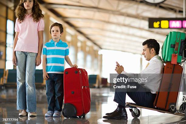 teenage girl and boy with businessman at airport terminal - airport frustration stock pictures, royalty-free photos & images