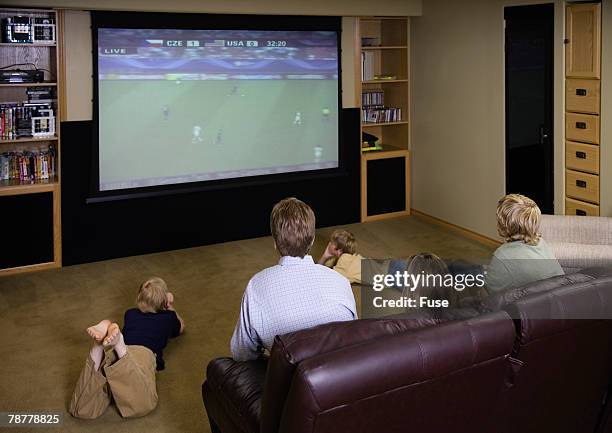 family watching television together - family watching tv from behind stockfoto's en -beelden