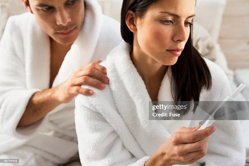 Woman Holding Pregnancy Test While Man Watches