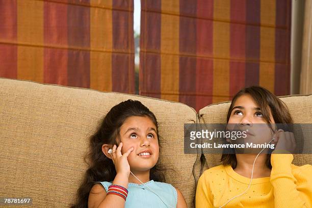 girls sharing headphones - liebelei lawrence stock-fotos und bilder