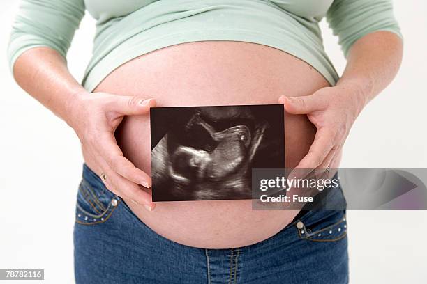 pregnant woman holding ultrasound image - ultra sonography stock pictures, royalty-free photos & images