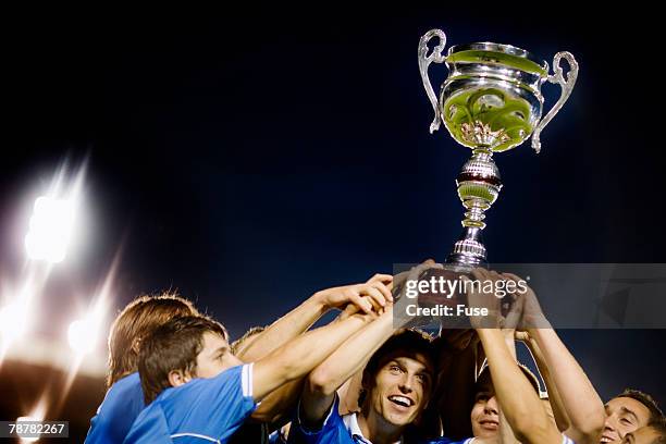 soccer team raising trophy - professional soccer team stock pictures, royalty-free photos & images