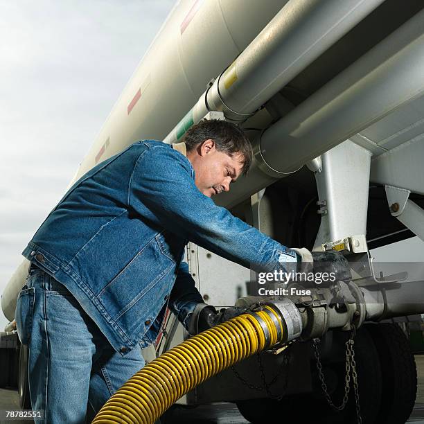 man pumping fuel from a fuel truck - 18 wheeler profile stock pictures, royalty-free photos & images