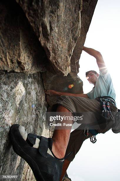 young man rock climbing - physical geography ストックフォトと画像