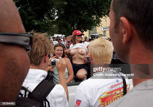 Group of on-lookers take photographs as a woman displays her breasts in the back of a vehicle during Street Machine Summernats 21 Car Festival at...